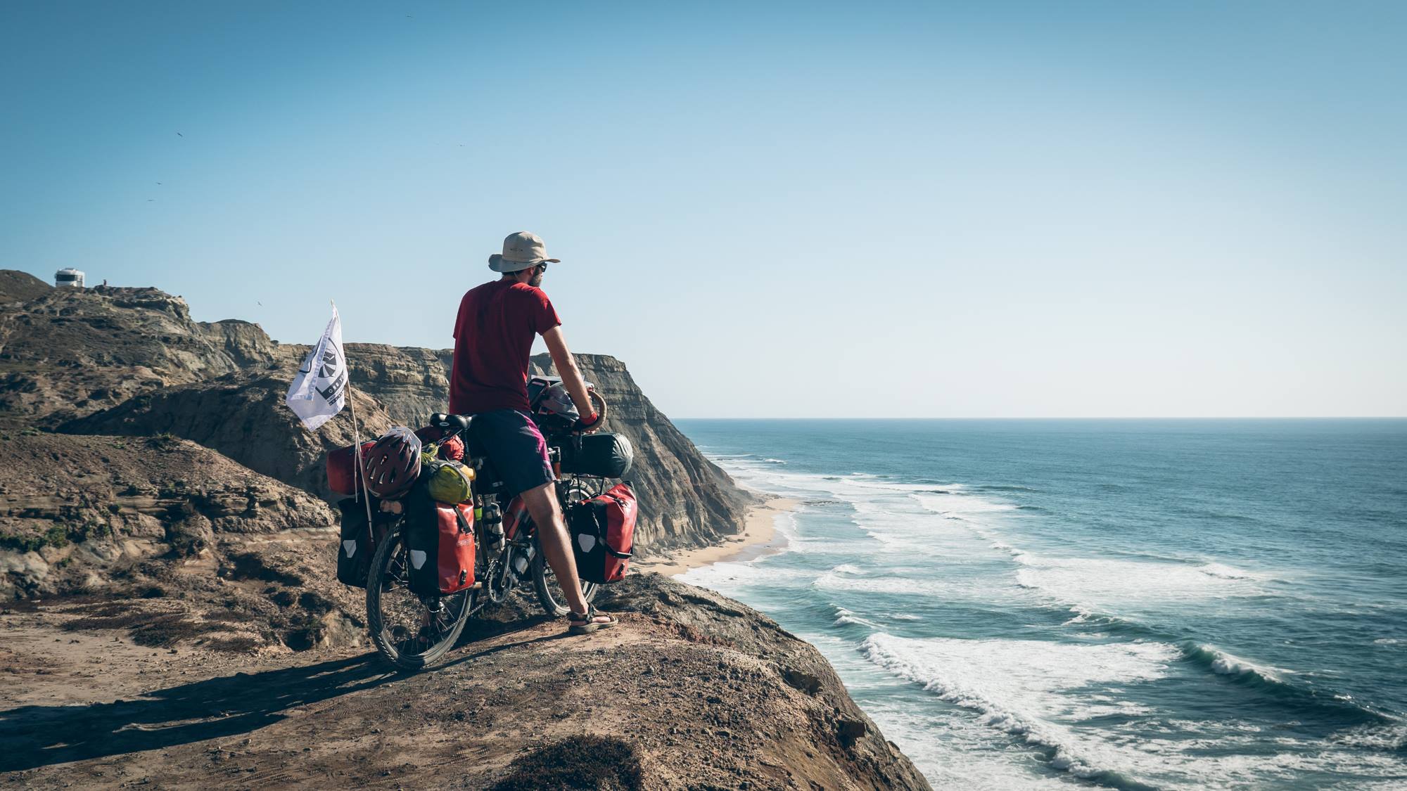 Guillaume de l'équipe Hey Bro au bord d'une falaise au Portugal sur l'Eurovélo 1